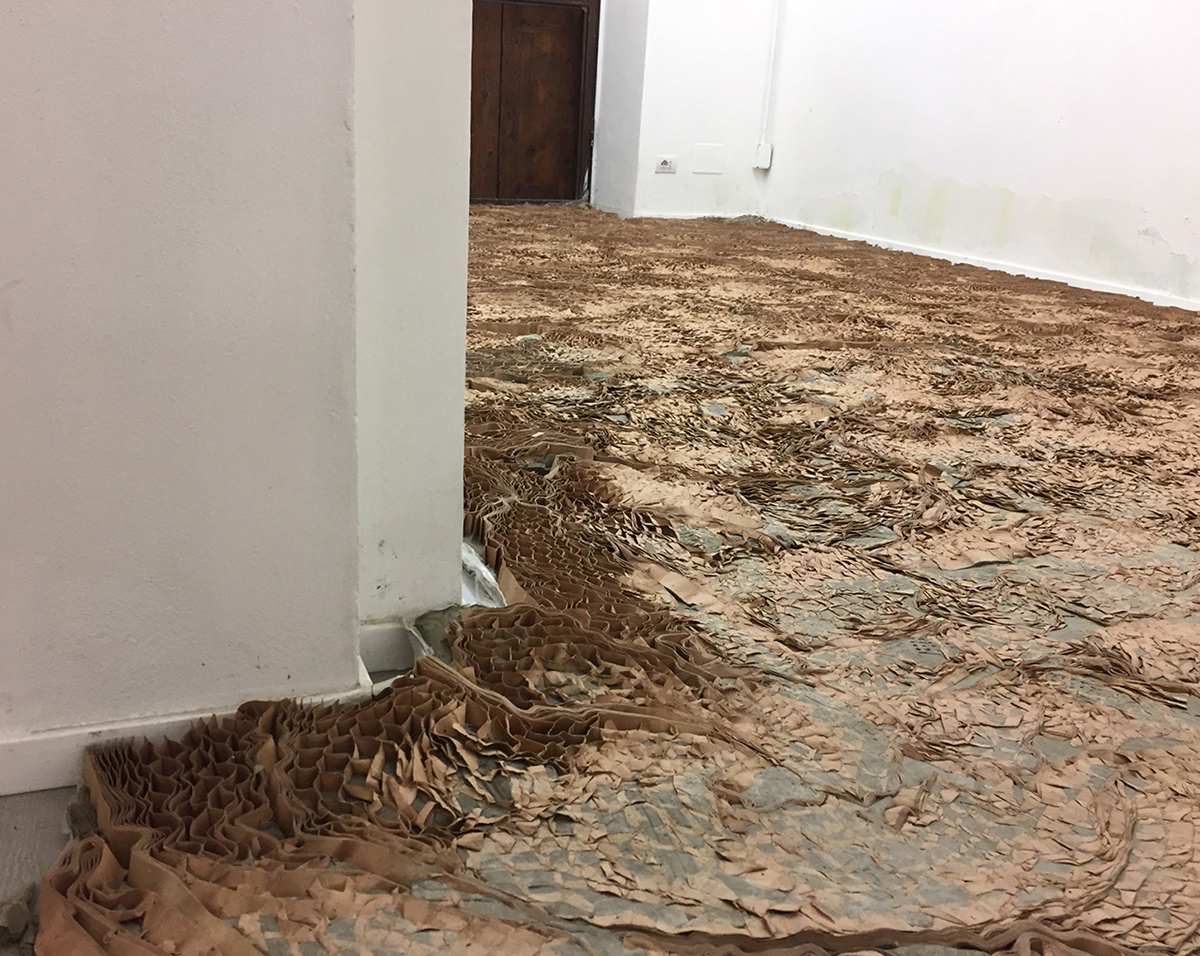 INFRA Intervento site specific Argilla cruda e cartone alveolare su pavimento